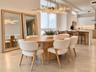 Open-concept interior featuring large-format tile flooring, a multi-tiered crystal statement chandelier, and a kitchen equipped with handleless flat-p