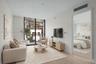Floor-to-ceiling windows, wood-finish flooring, and a private balcony