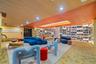 Custom floor-to-ceiling built-in library shelving with integrated LED illumination, wood-slat ceiling detailing, recessed lighting, and patterned carp