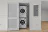 Laundry closet featuring a white louvered door and stacked white appliance set