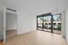 Interior space featuring wood-finish flooring, floor-to-ceiling windows, and a private balcony with a dark metal railing