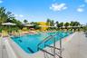 Swimming pool featuring a concrete surround, metal ladder entries, and integrated stone coping