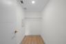 Enclosed storage space featuring wood-finish flooring, a white-coated wire shelf, and recessed ceiling lighting