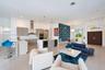 Open-concept living space featuring a gourmet kitchen with horizontal-grain cabinetry, quartz countertops, a stainless steel chimney-style range hood,