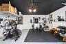 Garage space featuring epoxy-coated flooring, painted ceiling, and wall-mounted overhead storage shelving