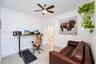 Neutral-toned tile flooring, white shaker-style interior door, and multi-blade ceiling fan with integrated light fixture