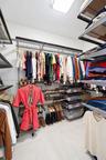 Walk-in closet featuring multi-tiered wire shelving, integrated hanging rods, built-in shoe racks, pull-out storage drawers, and tile flooring