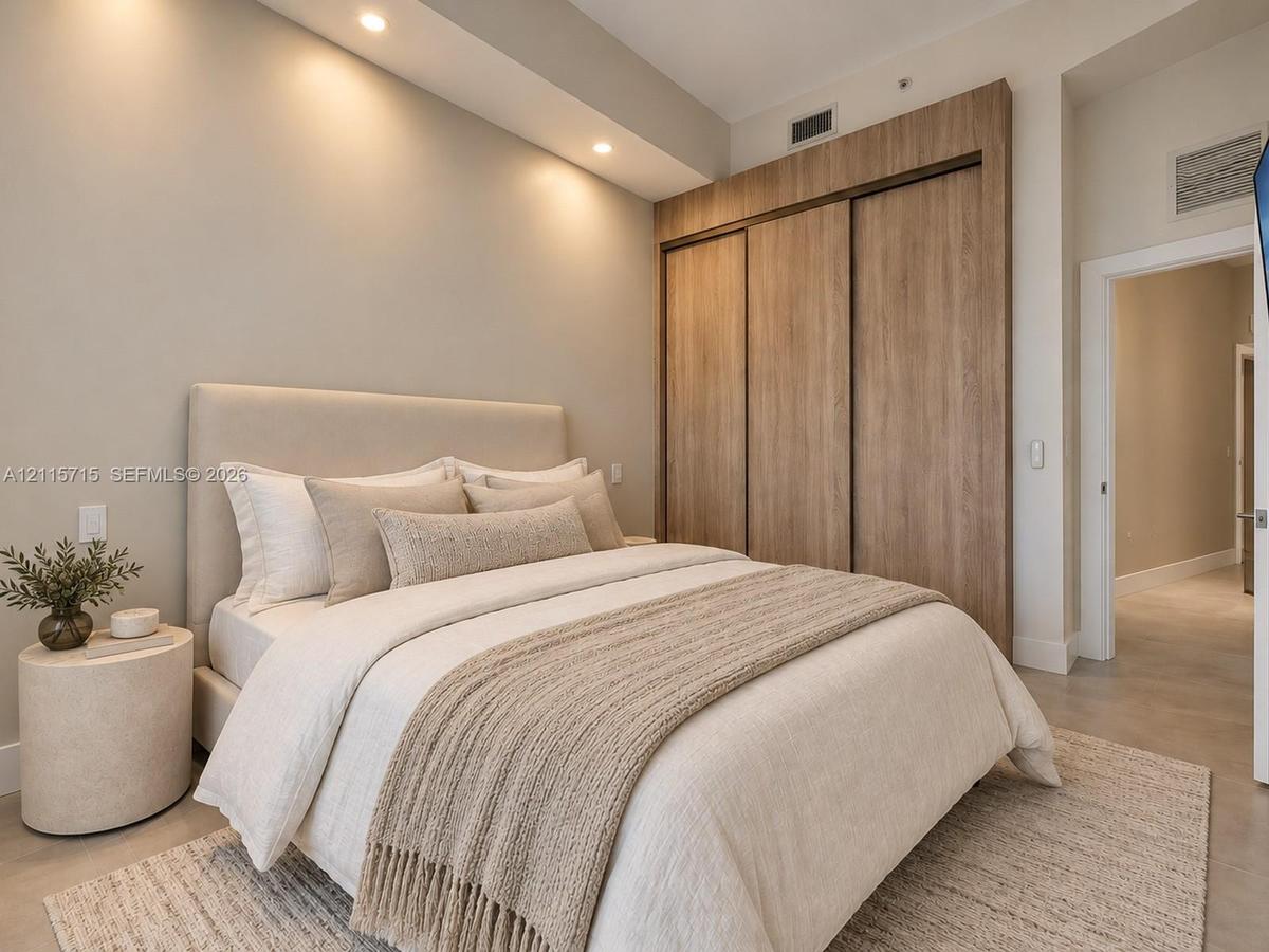 Built-in floor-to-ceiling wood-finish closet system, recessed ceiling lighting, and smooth-finish concrete flooring
