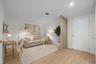 Interior space featuring wood-finish flooring, a decorative vertical slat partition, and a solid-core entry door with gold-toned hardware