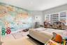 Room featuring a large-scale map wall mural, recessed ceiling lighting, and large windows with integrated blinds, finished with light-toned stone-styl