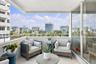 Covered balcony featuring a metal railing and terrazzo flooring, offering an expansive outlook of the surrounding cityscape