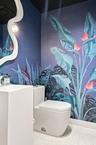 Powder room featuring botanical print wall covering, sculptural white pedestal sink with chrome faucet, high-profile dual-flush toilet, and wall-mount
