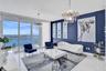Floor-to-ceiling glass windows, high-gloss tile flooring, dual multi-tiered crystal chandeliers, and an accent wall