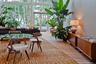 Floor-to-ceiling windows, glass-paned double doors, wood-finish flooring, and recessed wall sconces