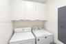 White flat-panel upper cabinetry with horizontal pulls providing overhead storage