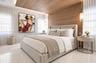 Wood-finish paneled ceiling and accent wall, polished light-toned stone flooring, and suspended cylindrical pendant lighting