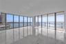 Floor-to-ceiling windows, wrap-around glass balcony railing, expansive stone tile flooring, and panoramic water exposure