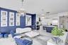 Open-concept living space featuring high-gloss flooring, tiered crystal chandeliers, two-tone custom cabinetry, a stone-topped kitchen island, and a d