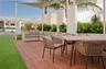Outdoor terrace featuring wood decking, a tensioned shade canopy, structural columns, and integrated landscaping