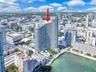 High-rise condominium building featuring glass-paneled exterior, private balcony, and on-site pool
