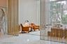 Double-height space featuring floor-to-ceiling metal chain drapery, high-gloss stone flooring, floor-to-ceiling stone wall paneling, and geometric tex