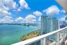Private balcony featuring a glass panel railing and panoramic water and skyline scenery