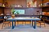 Custom wood-paneled walls featuring floor-to-ceiling built-in shelving, horizontal clerestory window, and wide-plank wood-finish flooring