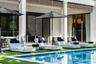 Covered patio featuring structural columns, decorative louvered detailing, sliding glass doors, and a swimming pool with tile edging