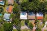Aerial perspective of a residential property featuring an in-ground swimming pool, concrete patio, red brick walkway, and mature perimeter trees