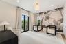 Neutral carpeted flooring, full-wall decorative mural, recessed lighting, brass-toned pendant fixture, and double glass doors providing outdoor access