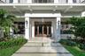 Covered entryway featuring a double-door glass entrance, concrete paver walkway with turf accents, dual exterior wall sconces, and architectural suppo