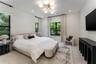 Spacious room featuring neutral wall tones, recessed lighting, a modern multi-globe chandelier, multi-pane windows with dark frames, and light wood-fi