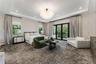 Tray ceiling featuring a globe-style multi-light fixture, patterned wall treatment, and black-framed multi-panel sliding glass doors opening to a balc