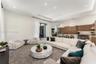 Open-concept space featuring a tray ceiling with recessed lighting, oversized glass panel doors, wood-finish cabinetry, a large kitchen island with st