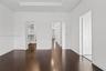 Room featuring wood-finish flooring, tray ceiling, and built-in closet shelving
