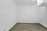Neutral-toned wood-finish flooring and smooth-textured white walls