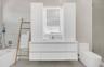 Modern vanity featuring a seamless countertop, integrated cabinetry, and an illuminated mirror