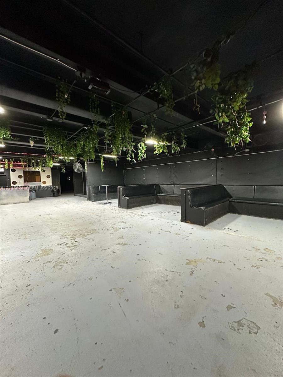 Expansive industrial-style interior featuring high ceilings with exposed ductwork, concrete flooring, and built-in perimeter bench seating