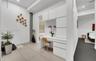 Built-in white cabinetry with integrated desk surface, large-format tile flooring, and vertical stone-texture architectural column