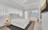 Tray ceiling, floor-to-ceiling sheer window treatments, transom windows, and light-tone tile flooring