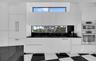 Modern kitchen featuring flat-panel white cabinetry, black stone countertops, built-in stainless steel double ovens, integrated refrigerator, and hori