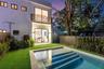 Modern exterior featuring a swimming pool with integrated stairs, synthetic lawn, wood-slat upper balcony railing, and floor-to-ceiling sliding glass 