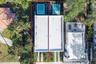 Aerial perspective of a property featuring a flat roofline, individual in-ground swimming pools, and concrete paver driveway strips