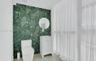 Bathroom featuring a green botanical-patterned tile accent wall, white vanity with an integrated basin, circular wall-mounted mirror, and wood-finish 