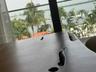 Floor-to-ceiling windows with expansive water scenery and palm tree backdrop