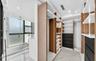 Custom walk-in closet featuring wood-finish cabinetry, built-in shelving, integrated LED accent lighting, and matte black drawer fronts