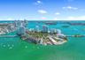 Aerial perspective of a coastal island community featuring waterfront positioning, expansive water surroundings, and proximity to municipal skylines