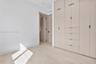 Floor-to-ceiling custom cabinetry with integrated storage, light wood-finish flooring, and recessed ceiling lighting