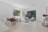 Living area featuring light-toned wood-finish flooring, sliding glass doors, recessed lighting, and a square window