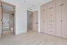 Floor-to-ceiling built-in cabinetry featuring integrated drawers and matte black hardware, wood-finish flooring, and recessed ceiling lighting